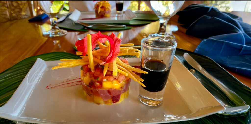 “Gourmet tuna and mango tartare topped with crispy strips and edible flowers, served with house-made sauce at Drake Bay Greenleaf.