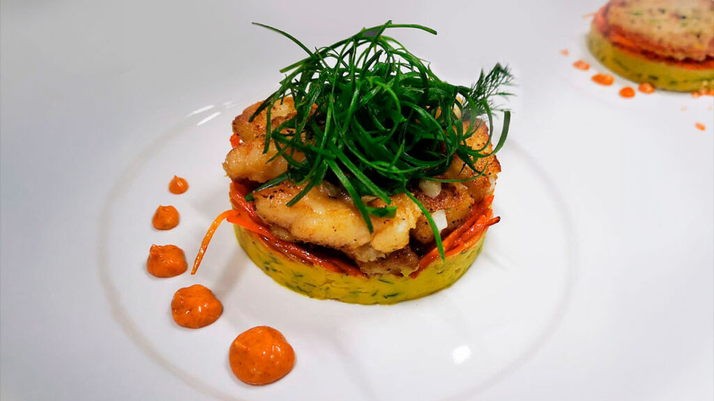 Gourmet seafood and vegetable stack with mashed base, carrot slices, and herbs at Drake Bay Greenleaf